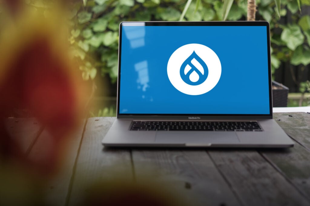 Drupal logo, a free and open source web content management system (cms) written in php, displayed on a macbook pro screen